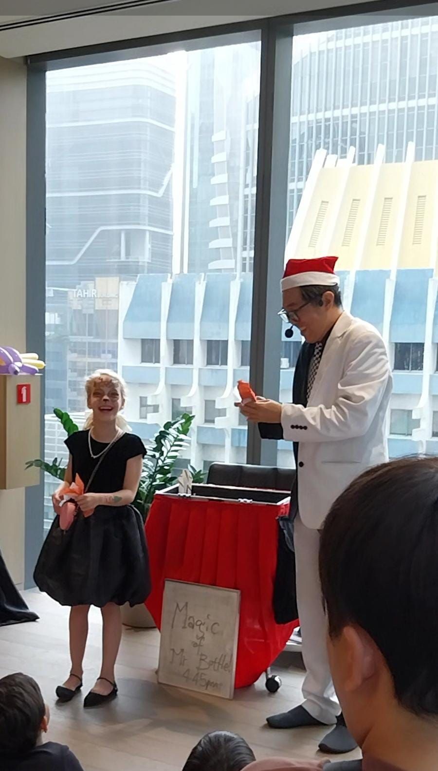 Happy magician wearing santa hat performing a christmas hat magic