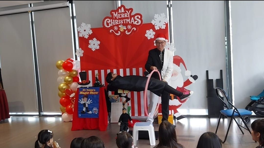 Magician with floating a child on top of Santa's toys